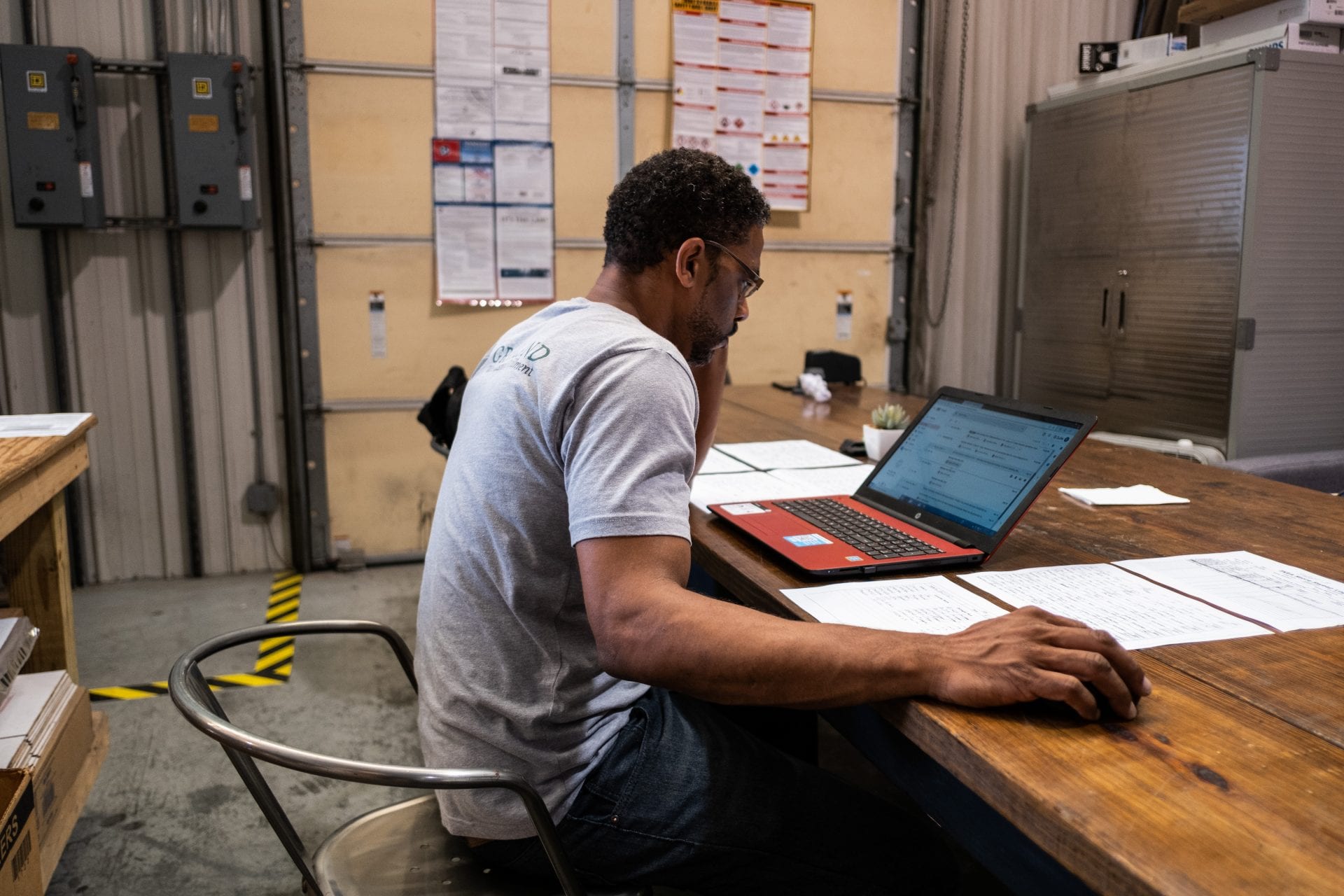 Male Employee working on computer at Large Warehouse Distribution Center Nashville TN ready to complete kitting, pick and pack, and cross docking services